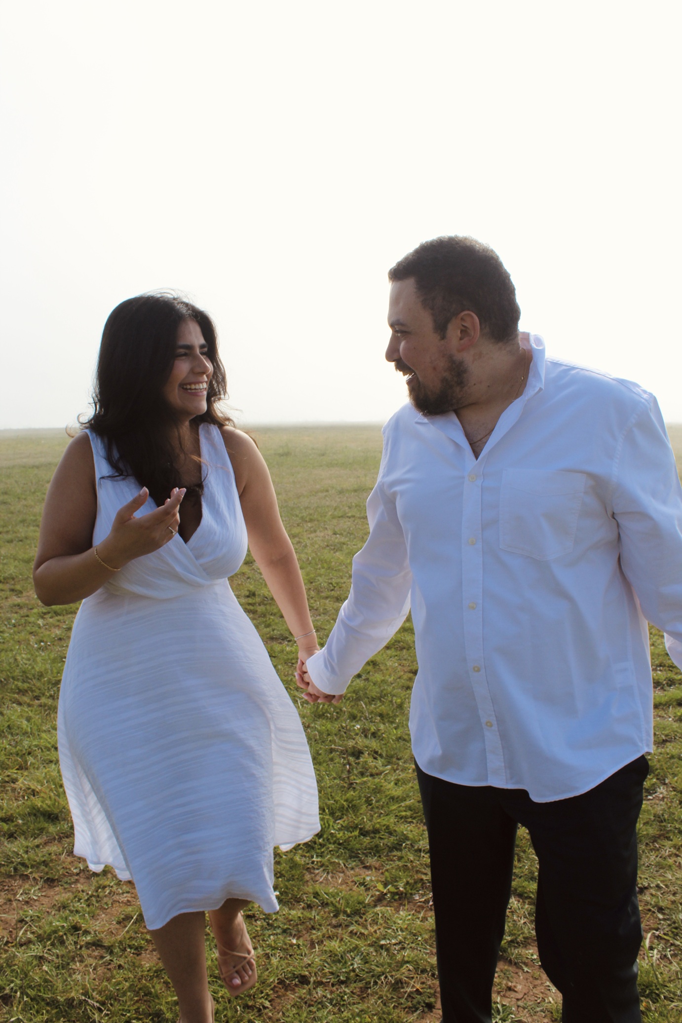 Roger and Rita walking hand in hand through a misty field, both dressed in white.