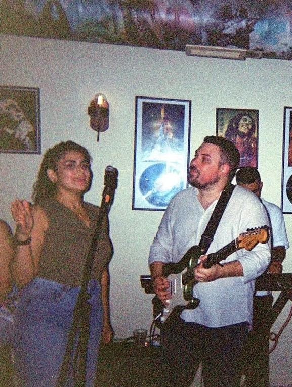 Rita at the microphone while Roger plays electric guitar first concert together.